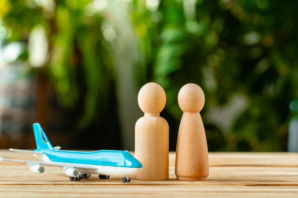 Family travel and vacation concept. Wooden figures of family and toy plane
